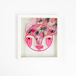 Framed artwork with a stylized face design on a white background
